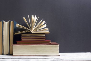 Açık kitap, ahşap masadaki ciltli kitaplar. Okula dönelim. Boşluğu kopyala