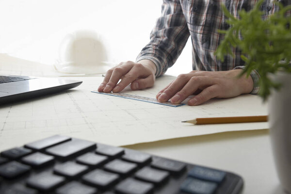 Architects working on blueprint, real estate project. Architect workplace - architectural project, blueprints, ruler, calculator, laptop and divider compass. Construction concept. Engineering tools.