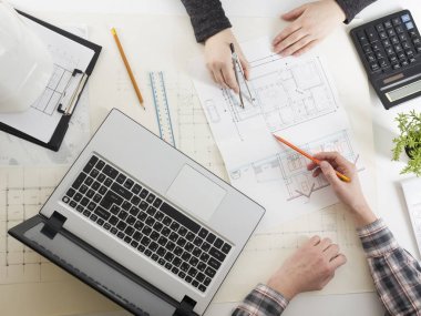 Mimarlar Blueprint, gayrimenkul projesi üzerinde çalışıyor. Mimar işyeri - mimari proje, planları, cetvel, hesap makinesi, laptop ve bölücü pusula. İnşaat kavramı. Mühendislik araçları.
