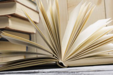 Açık kitap, ahşap masadaki ciltli kitaplar. Okula dönelim. Boşluğu kopyala