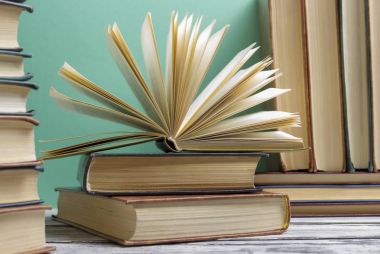 Açık kitap, ahşap masadaki ciltli kitaplar. Okula dönelim. Boşluğu kopyala