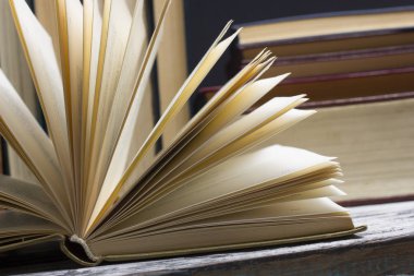 Açık kitap, ahşap masadaki ciltli kitaplar. Okula dönelim. Boşluğu kopyala