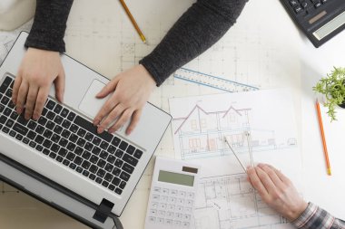 Mimarlar Blueprint, gayrimenkul projesi üzerinde çalışıyor. Mimar işyeri - mimari proje, planları, cetvel, hesap makinesi, laptop ve bölücü pusula. İnşaat kavramı. Mühendislik araçları.