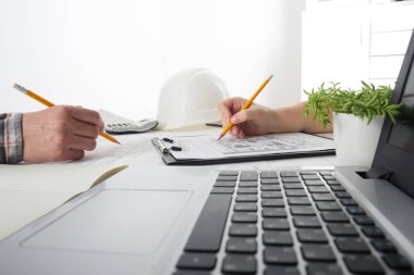 Mimarlar Blueprint, gayrimenkul projesi üzerinde çalışıyor. Mimar işyeri - mimari proje, planları, cetvel, hesap makinesi, laptop ve bölücü pusula. İnşaat kavramı. Mühendislik araçları.