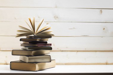 Açık kitap, ahşap masadaki ciltli kitaplar. Okula dönelim. Boşluğu kopyala