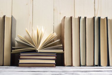Açık kitap, ahşap masadaki ciltli kitaplar. Okula dönelim. Boşluğu kopyala