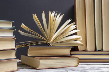 Açık kitap, ahşap masadaki ciltli kitaplar. Okula dönelim. Boşluğu kopyala