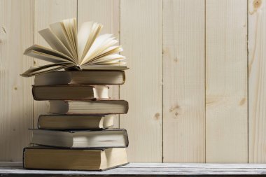 Açık kitap, ahşap masadaki ciltli kitaplar. Okula dönelim. Boşluğu kopyala