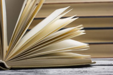 Açık kitap, ahşap masadaki ciltli kitaplar. Okula dönelim. Boşluğu kopyala