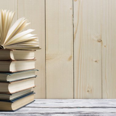 Açık kitap, ahşap masadaki ciltli kitaplar. Okula dönelim. Boşluğu kopyala