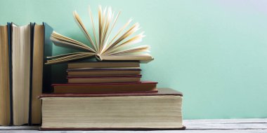 Açık kitap, ahşap masadaki ciltli kitaplar. Okula dönelim. Boşluğu kopyala