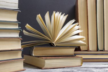 Açık kitap, ahşap masadaki ciltli kitaplar. Okula dönelim. Boşluğu kopyala