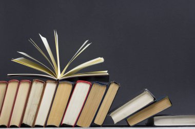 Açık kitap, ahşap masadaki ciltli kitaplar. Okula dönelim. Boşluğu kopyala