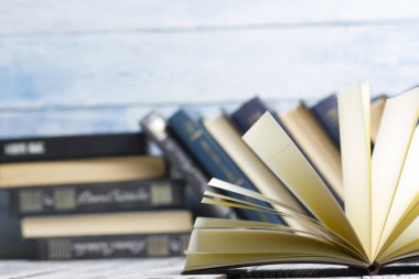 Açık kitap, ahşap masadaki ciltli kitaplar. Okula dönelim. Boşluğu kopyala