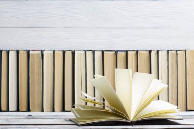 Açık kitap, ahşap masadaki ciltli kitaplar. Okula dönelim. Boşluğu kopyala