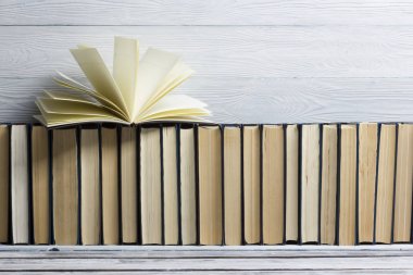 Açık kitap, ahşap masadaki ciltli kitaplar. Okula dönelim. Boşluğu kopyala