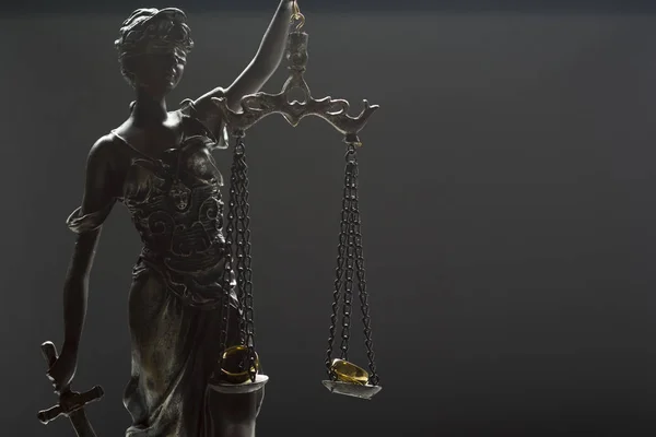 Концепция развода. обручальные кольца и статуя правосудия — стоковое фото