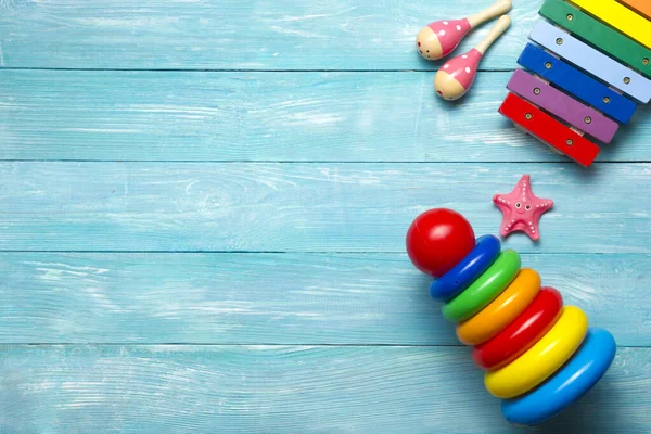 Colorato bambini giocattoli cornice su sfondo di legno. Vista dall'alto. Piatto. Copia spazio per testo . — Foto Stock