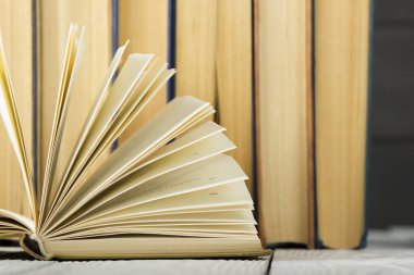Açık kitap, ahşap masadaki ciltli kitaplar. Okula dönelim. Boşluğu kopyala