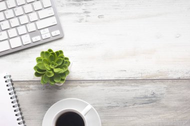 Bilgisayarlı beyaz masa ofisi, akıllı telefon ve bir fincan kahveli diğer iş malzemeleri. Metni kopyalamak için üst görünümü kullan. Desenci çalışma alanı düz masa üzerinde temel elementler yatıyordu