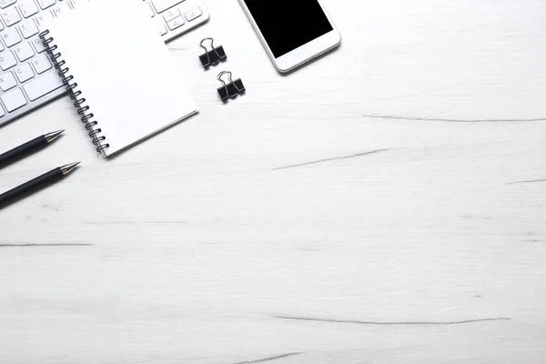 White desk office with laptop, smartphone and other work supplies with cup of coffee. Top view with copy space for input the text. Designer workspace on desk table essential elements on flat lay