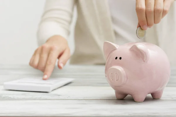 Mão mulher colocando dinheiro moeda em porquinho para economizar dinheiro riqueza e conceito financeiro — Fotografia de Stock