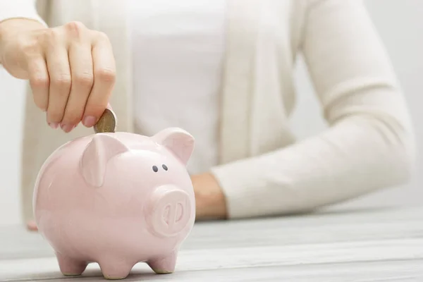 Mão mulher colocando dinheiro moeda em porquinho para economizar dinheiro riqueza e conceito financeiro — Fotografia de Stock