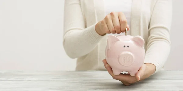 Γυναίκα χέρι βάζοντας χρήματα νόμισμα σε piggy για την εξοικονόμηση πλούτου χρήματα και την οικονομική έννοια — Φωτογραφία Αρχείου