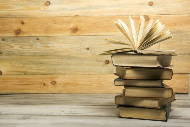 Açık kitap, ahşap masadaki ciltli kitaplar. Okula dönelim. Boşluğu kopyala.