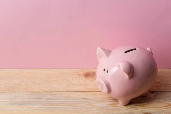 Um banco porquinho e dinheiro em dinheiro. Conceito de negócios, finanças, investimento, poupança e corrupção. — Fotografia de Stock