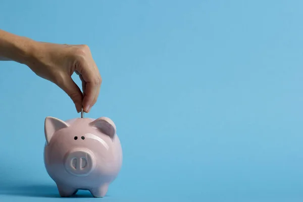 Donna mano mettendo moneta denaro nel maialino per risparmiare denaro ricchezza e concetto finanziario — Foto Stock