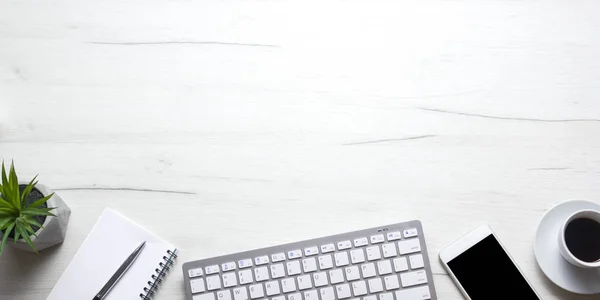 White desk office with laptop, smartphone and other work supplies with cup of coffee. Top view with copy space for input the text. Designer workspace on desk table essential elements on flat lay