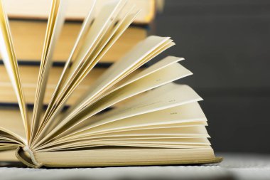 Açık kitap, ahşap masadaki ciltli kitaplar. Okula dönelim. Boşluğu kopyala