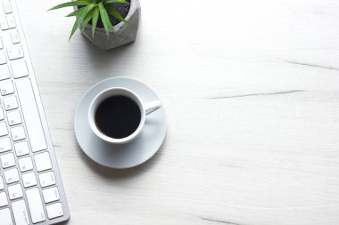 Bilgisayarlı beyaz masa ofisi, akıllı telefon ve bir fincan kahveli diğer iş malzemeleri. Metni kopyalamak için üst görünümü kullan. Desenci çalışma alanı düz masa üzerinde temel elementler yatıyordu