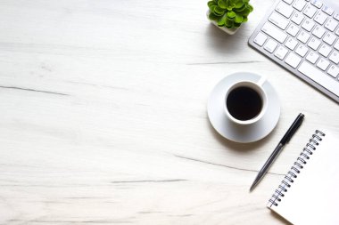 Bilgisayarlı beyaz masa ofisi, akıllı telefon ve bir fincan kahveli diğer iş malzemeleri. Metni kopyalamak için üst görünümü kullan. Desenci çalışma alanı düz masa üzerinde temel elementler yatıyordu