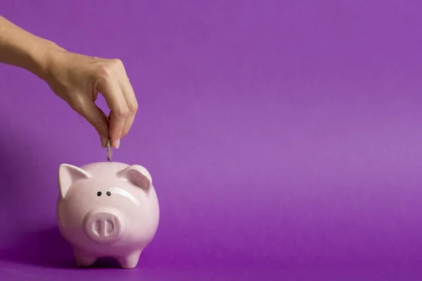 Vrouw hand zetten geld munt in piggy voor het besparen van geld rijkdom en financieel concept — Stockfoto