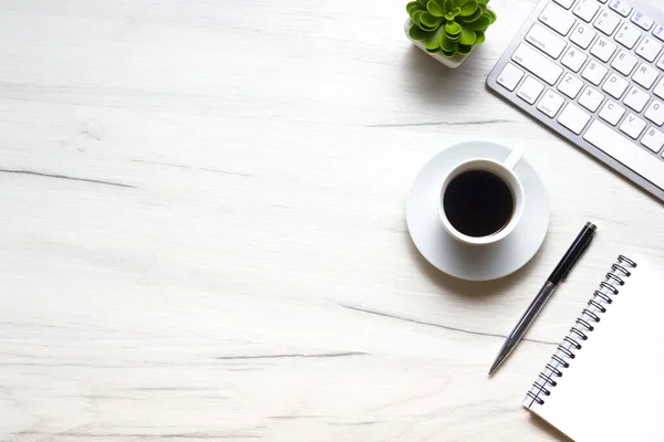Bilgisayarlı beyaz masa ofisi, akıllı telefon ve bir fincan kahveli diğer iş malzemeleri. Metni kopyalamak için üst görünümü kullan. Desenci çalışma alanı düz masa üzerinde temel elementler yatıyordu