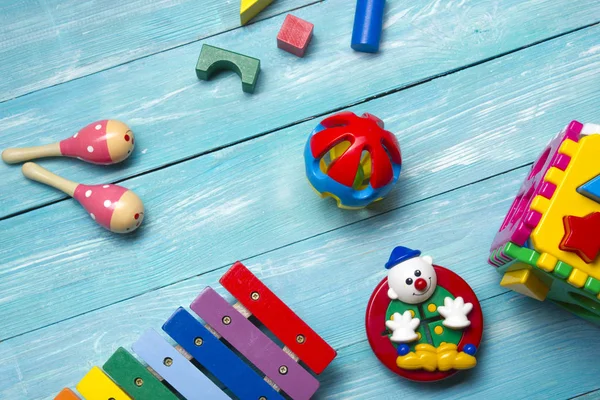 Crianças coloridas brinquedos quadro no fundo de madeira. Vista superior. Deitado. Espaço de cópia para texto . — Fotografia de Stock