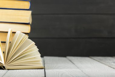 Açık kitap, ahşap masadaki ciltli kitaplar. Okula dönelim. Boşluğu kopyala