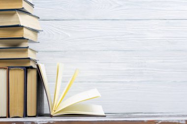 Açık kitap, ahşap masadaki ciltli kitaplar. Okula dönelim. Boşluğu kopyala