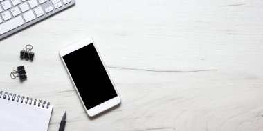Bilgisayarlı beyaz masa ofisi, akıllı telefon ve bir fincan kahveli diğer iş malzemeleri. Metni kopyalamak için üst görünümü kullan. Desenci çalışma alanı düz masa üzerinde temel elementler yatıyordu