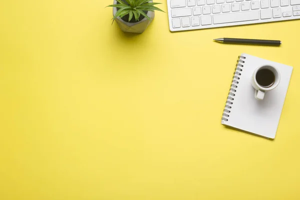 Escritório mesa amarela com laptop, smartphone e outros suprimentos de trabalho com xícara de café. Visão superior com espaço de cópia para entrada do texto. Espaço de trabalho de designer na mesa de mesa elementos essenciais em leigos planos — Fotografia de Stock