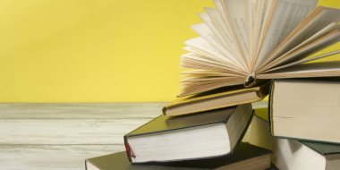 Açık kitap, ahşap masadaki ciltli kitaplar. Okula dönelim. Boşluğu kopyala