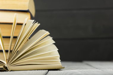 Açık kitap, ahşap masadaki ciltli kitaplar. Okula dönelim. Boşluğu kopyala