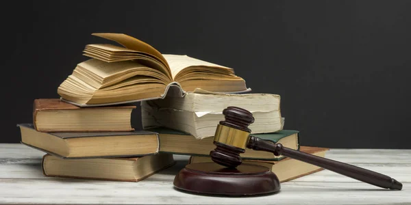 Law concept - Open law book with a wooden judges gavel on table in a courtroom or law enforcement office isolated on white background. Copy space for text. — Stock Photo, Image