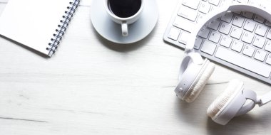 Bilgisayarlı beyaz masa ofisi, akıllı telefon ve bir fincan kahveli diğer iş malzemeleri. Metni kopyalamak için üst görünümü kullan. Desenci çalışma alanı düz masa üzerinde temel elementler yatıyordu