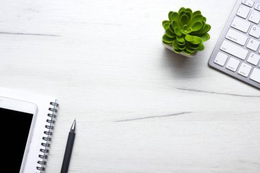 Bilgisayarlı beyaz masa ofisi, akıllı telefon ve bir fincan kahveli diğer iş malzemeleri. Metni kopyalamak için üst görünümü kullan. Desenci çalışma alanı düz masa üzerinde temel elementler yatıyordu