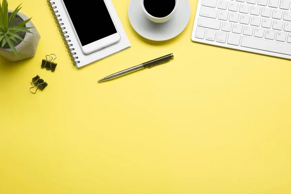 Escritorio amarillo con laptop, smartphone y otros suministros de trabajo con taza de café. Vista superior con espacio de copia para introducir el texto. Diseñador de espacio de trabajo en mesa de escritorio elementos esenciales en la disposición plana — Foto de Stock
