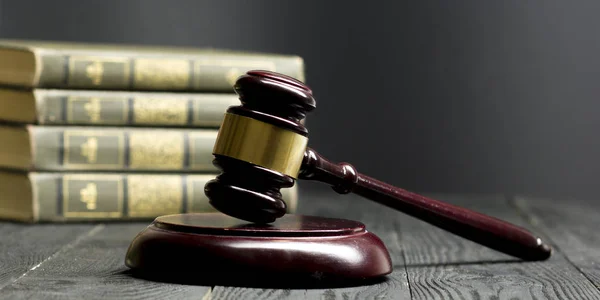 Law concept - Open law book with a wooden judges gavel on table in a courtroom or law enforcement office isolated on white background. Copy space for text.