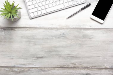 Bilgisayarlı beyaz masa ofisi, akıllı telefon ve bir fincan kahveli diğer iş malzemeleri. Metni kopyalamak için üst görünümü kullan. Desenci çalışma alanı düz masa üzerinde temel elementler yatıyordu